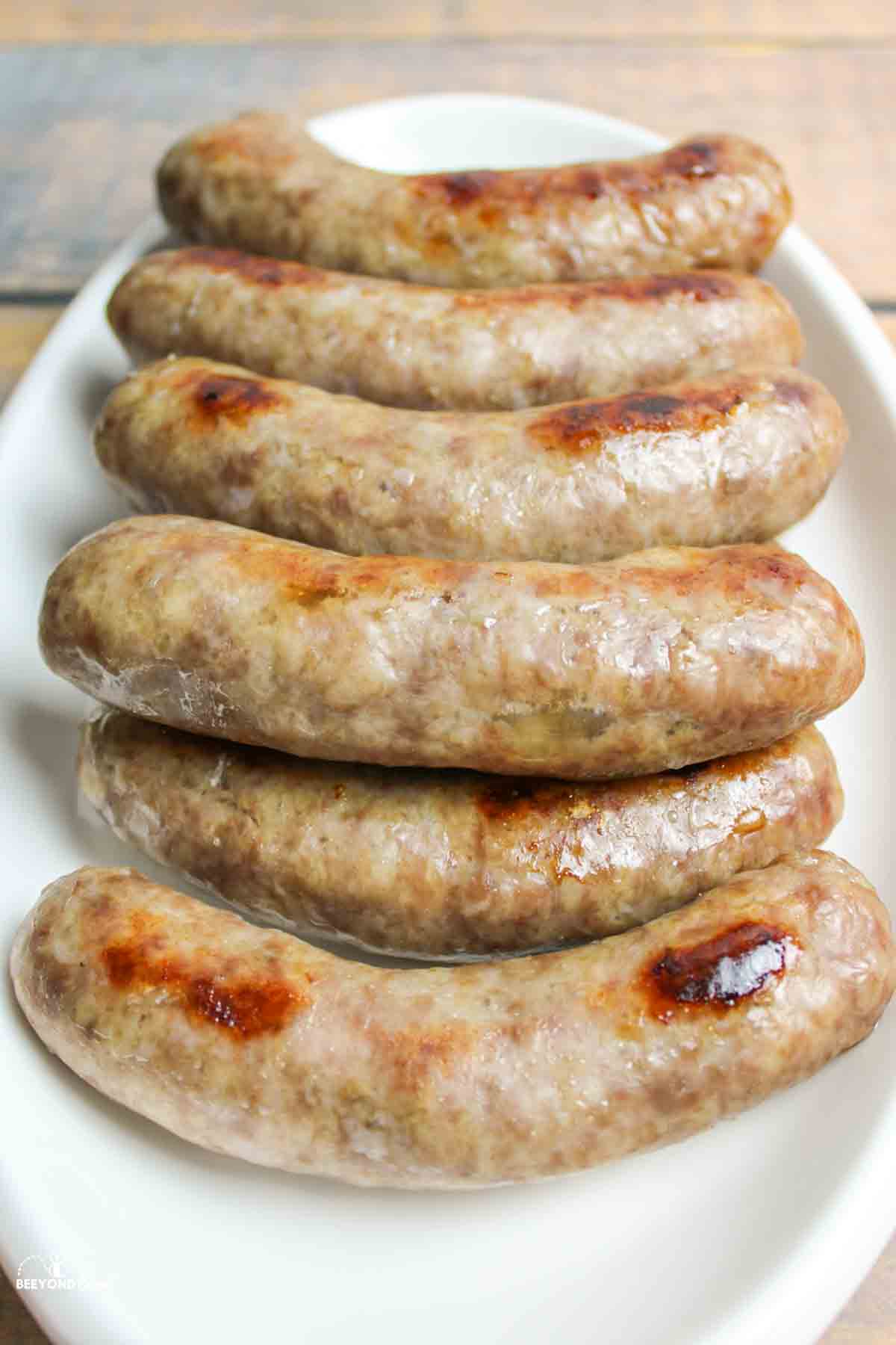 platter full of cooked juicy brats.