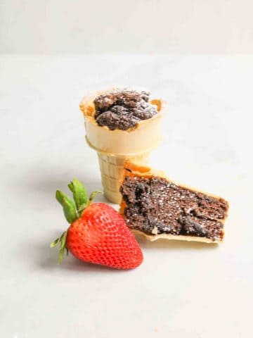 a full brownie cone with a split brownie cone and a fresh strawberry to the front
