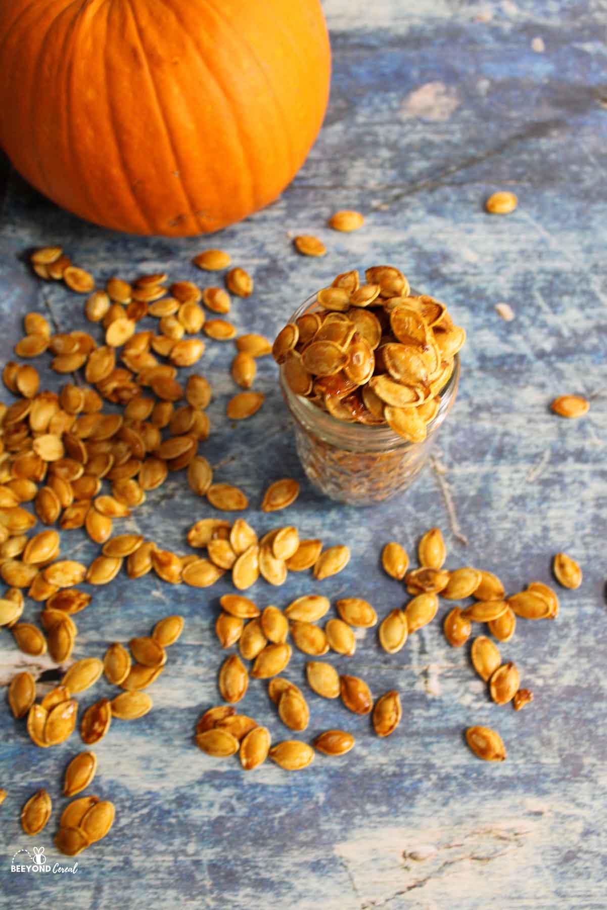 an above view of honey roasted pumpkin seeds in a jar and scattered around