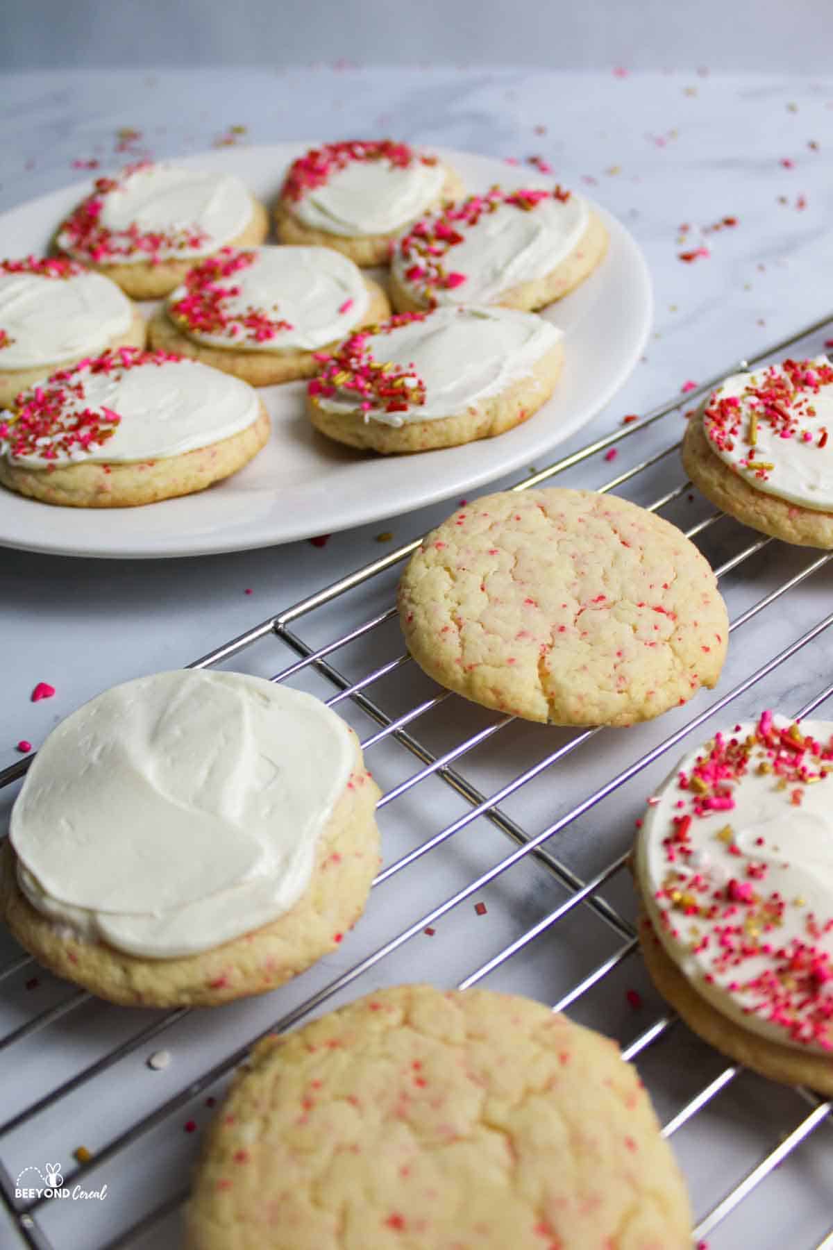 cherry chip cookies some with frosting and sprinkles and some without.