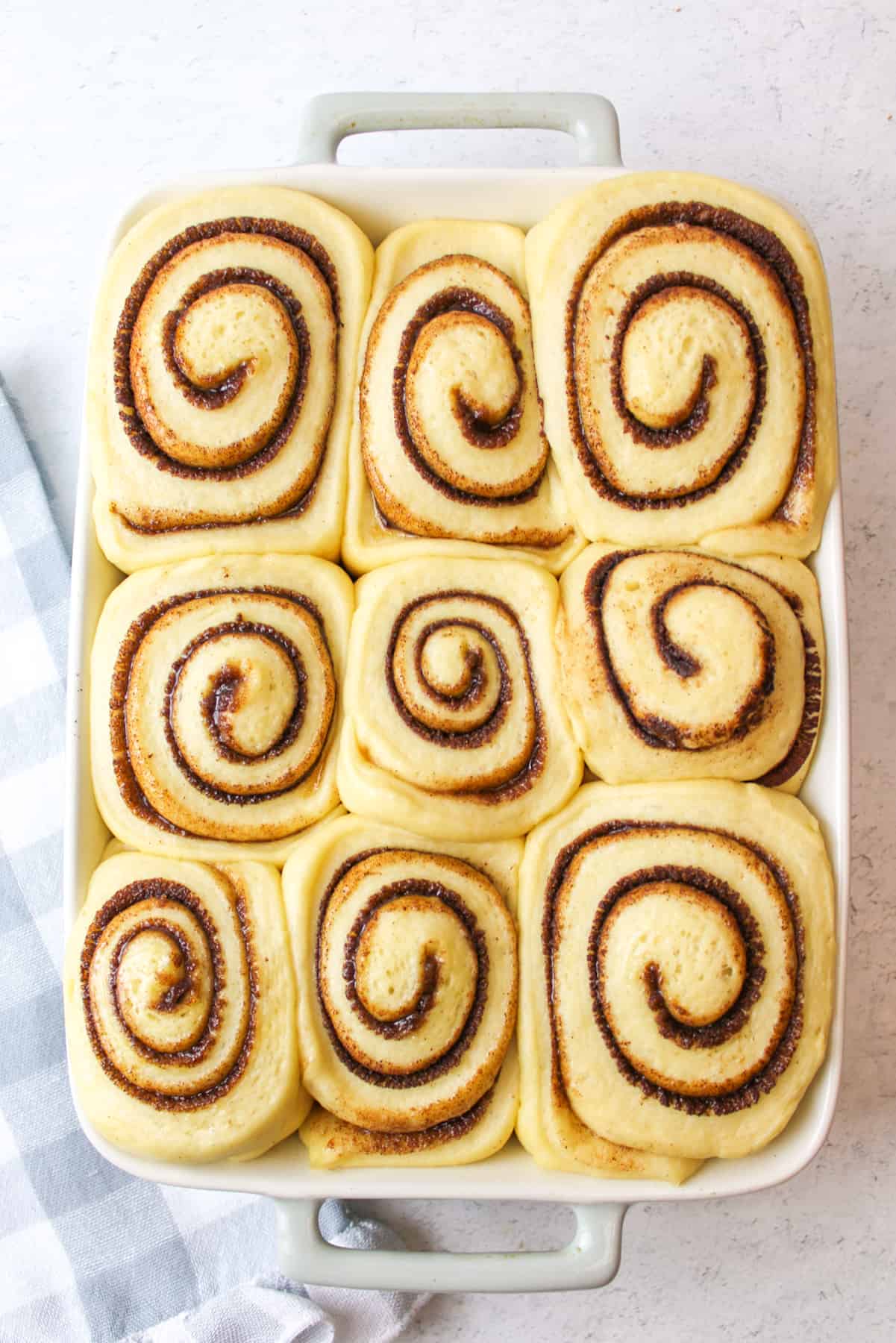 doubled in size and proofed cinnamon rolls in a baking dish.