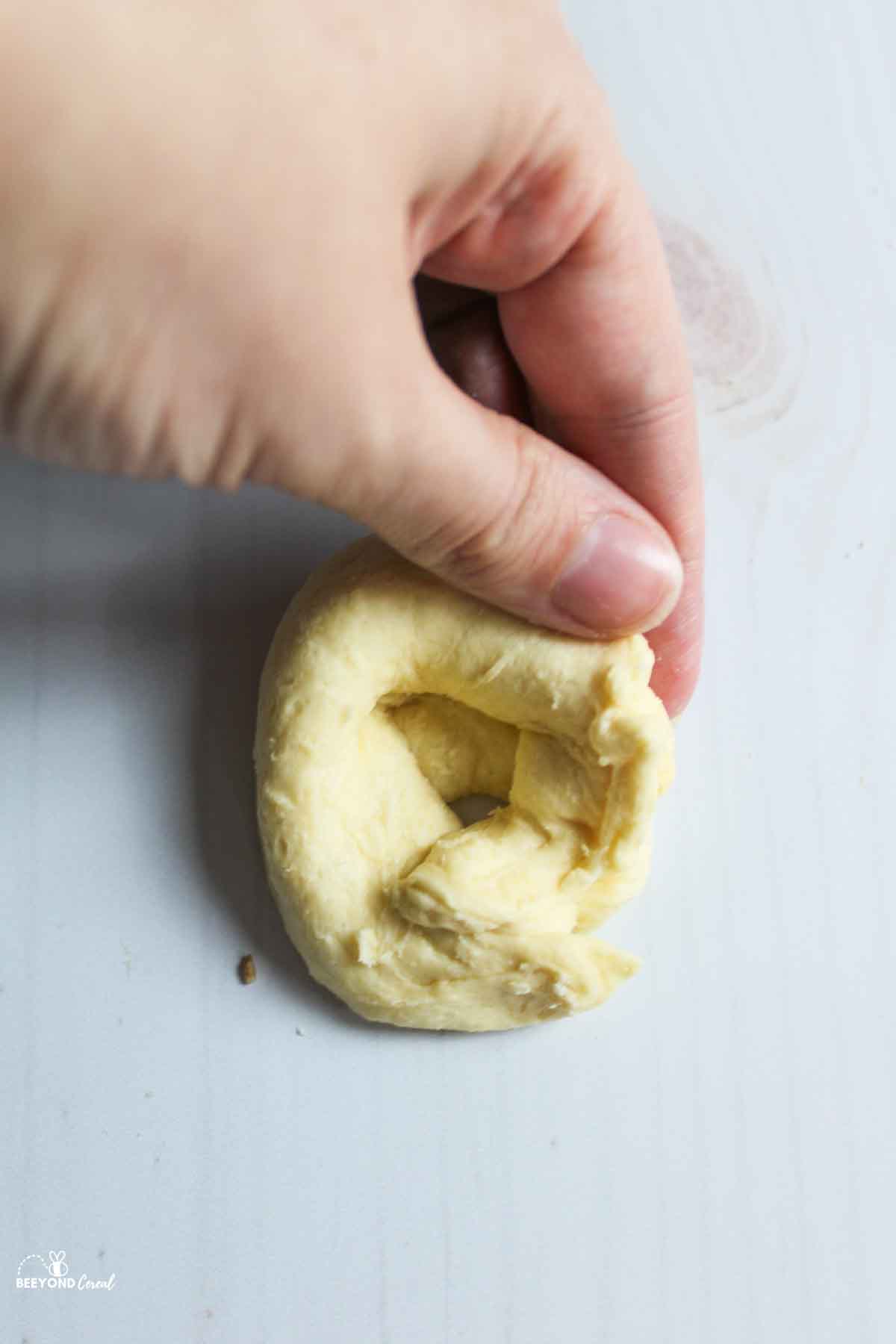 hand folding the crescent dough into a bowl.