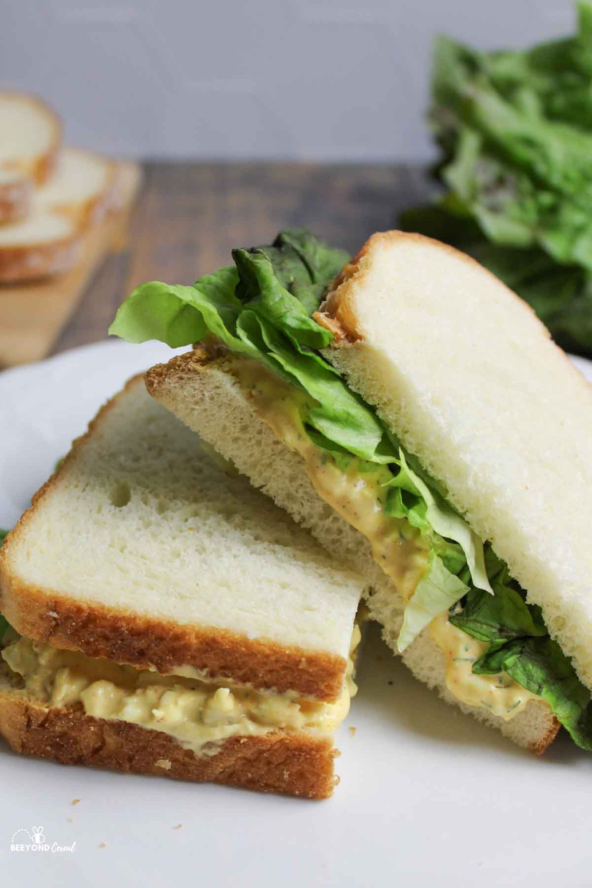 egg salad sandwich halves stacked on a plate