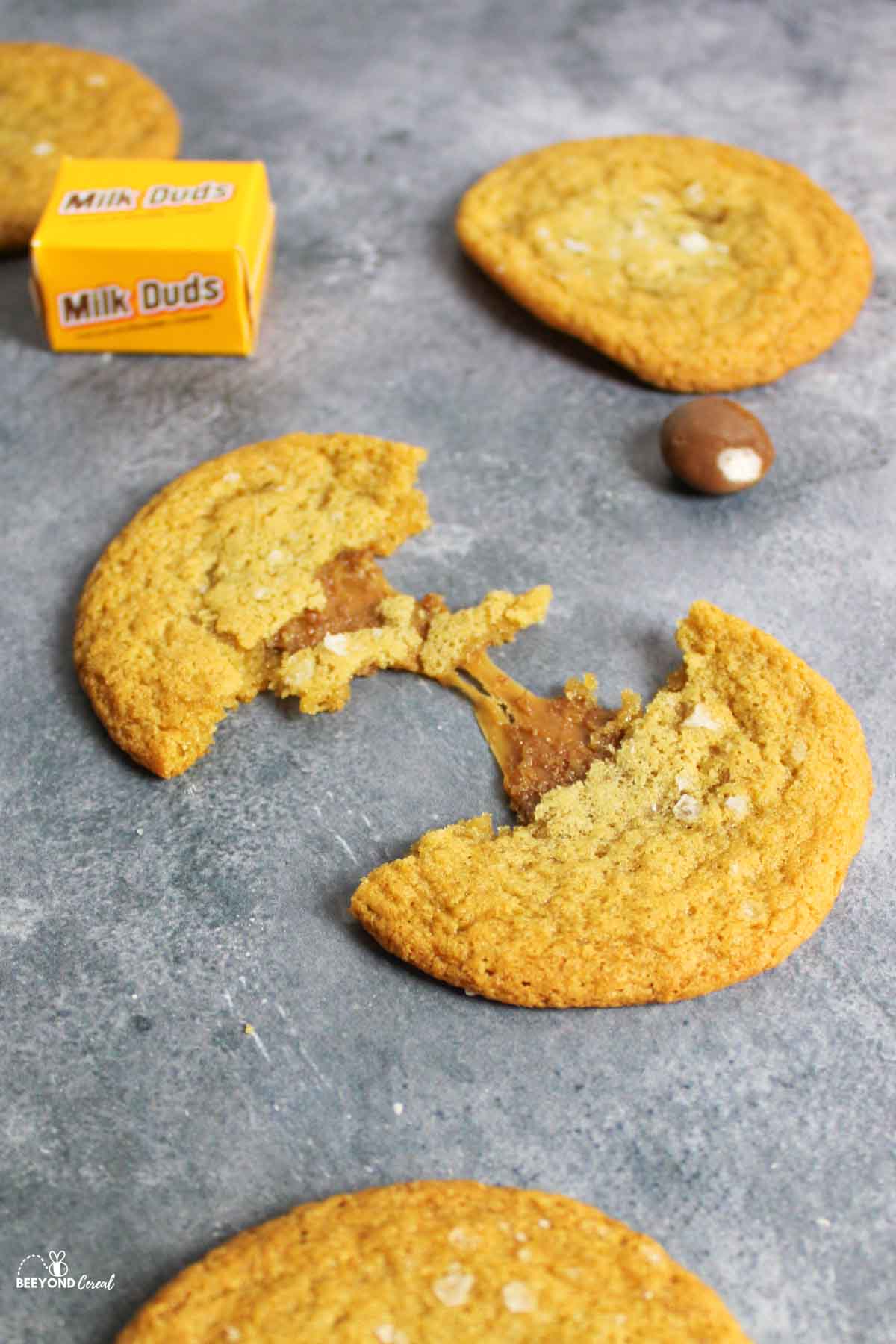 a broken milk dud cookie to show the chewy caramel inside