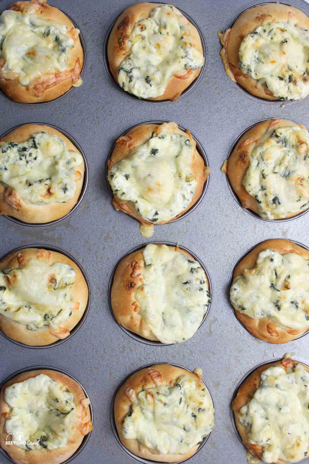 a close up aerial view of spinach dip bowls in a muffin pan