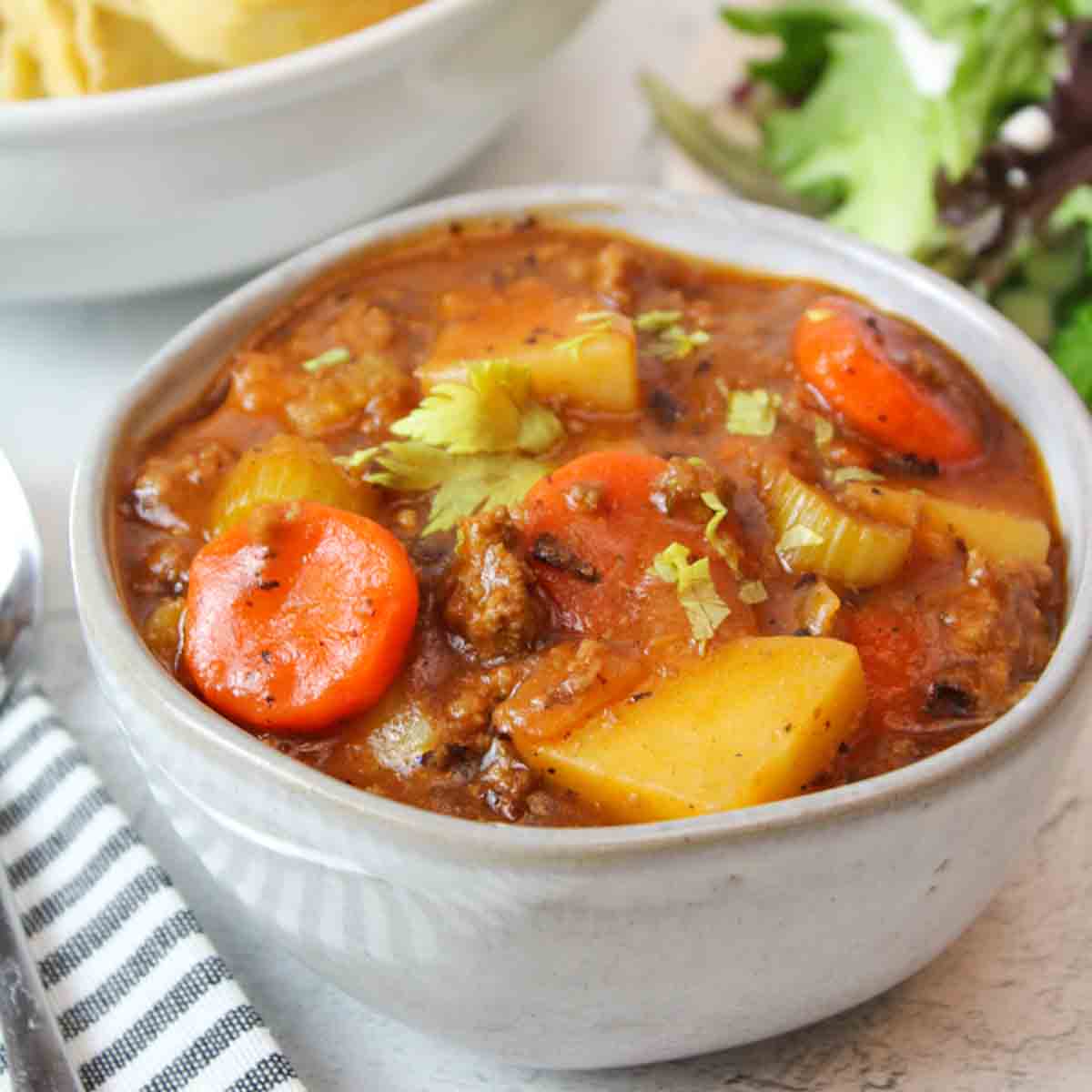 a bowl full of soup and a spoon to the side.