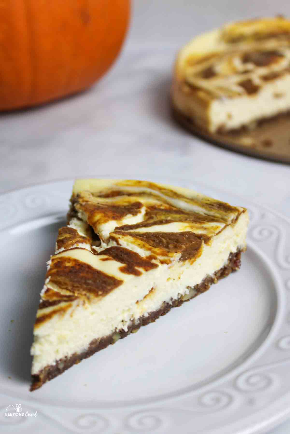 a slice of pumpkin swirl cheesecake on a plate.