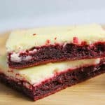 red velvet cheesecake brownie stacked two high on wooden cutting board