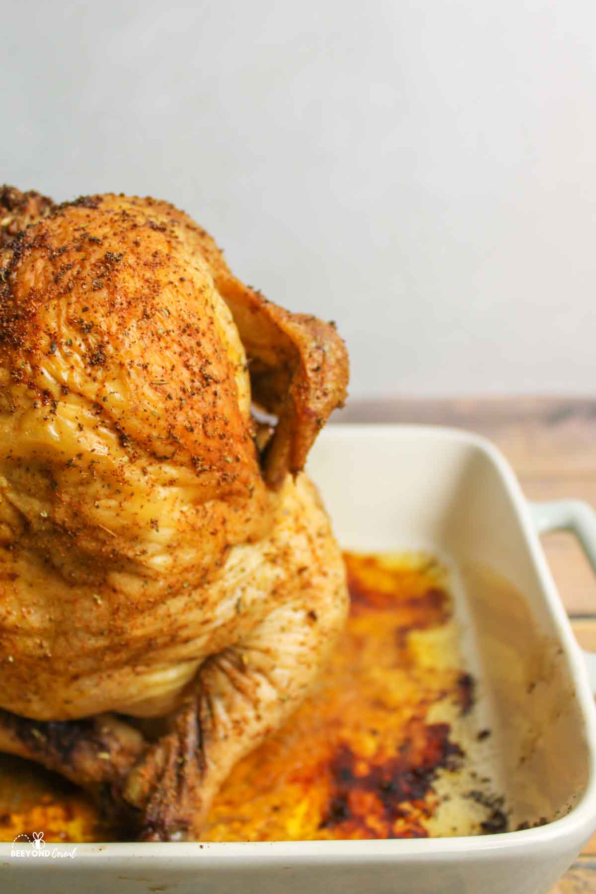 half of a baked beer can chicken in a baking dish