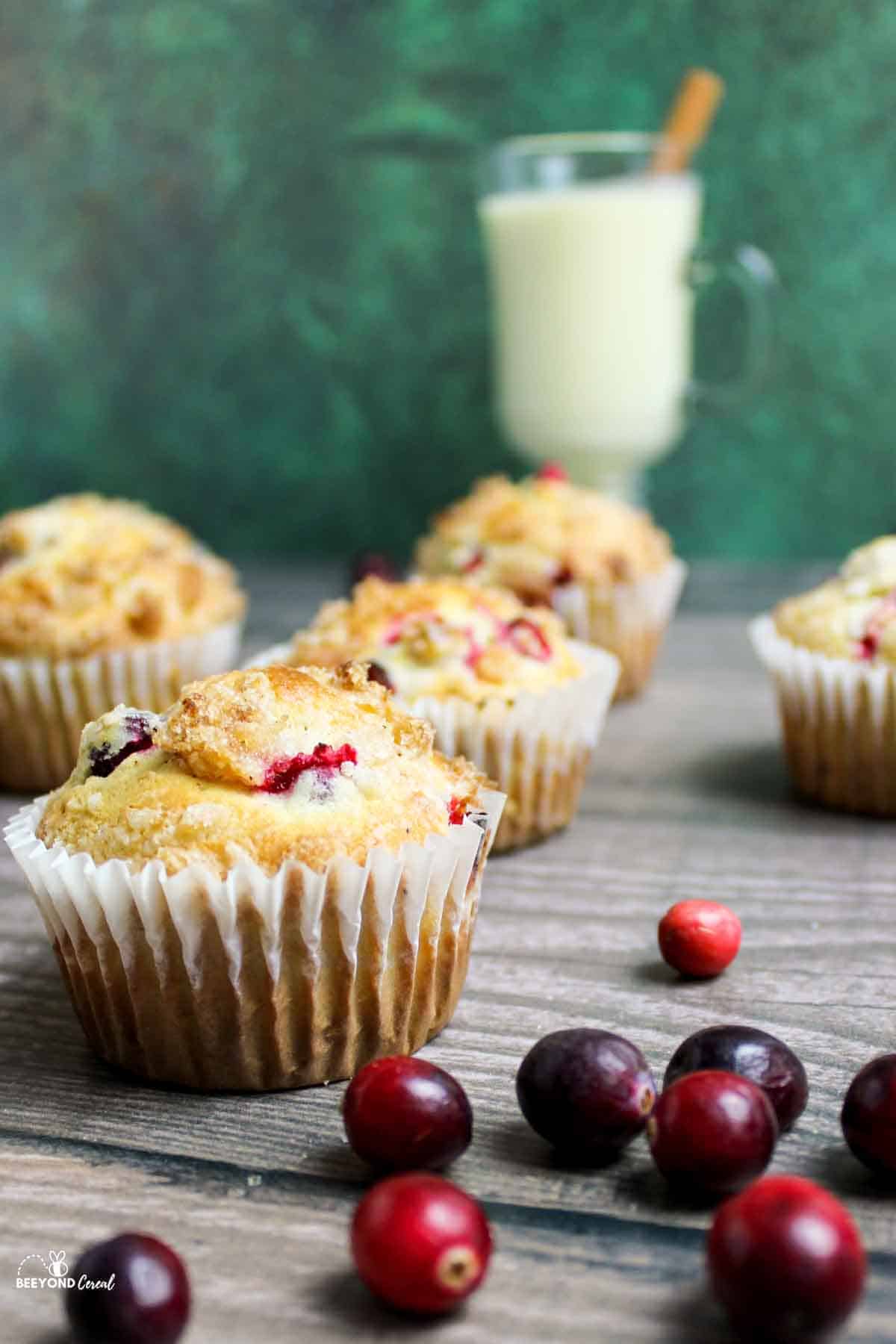 cranberry eggnog muffins with fresh cranberries scattered around.