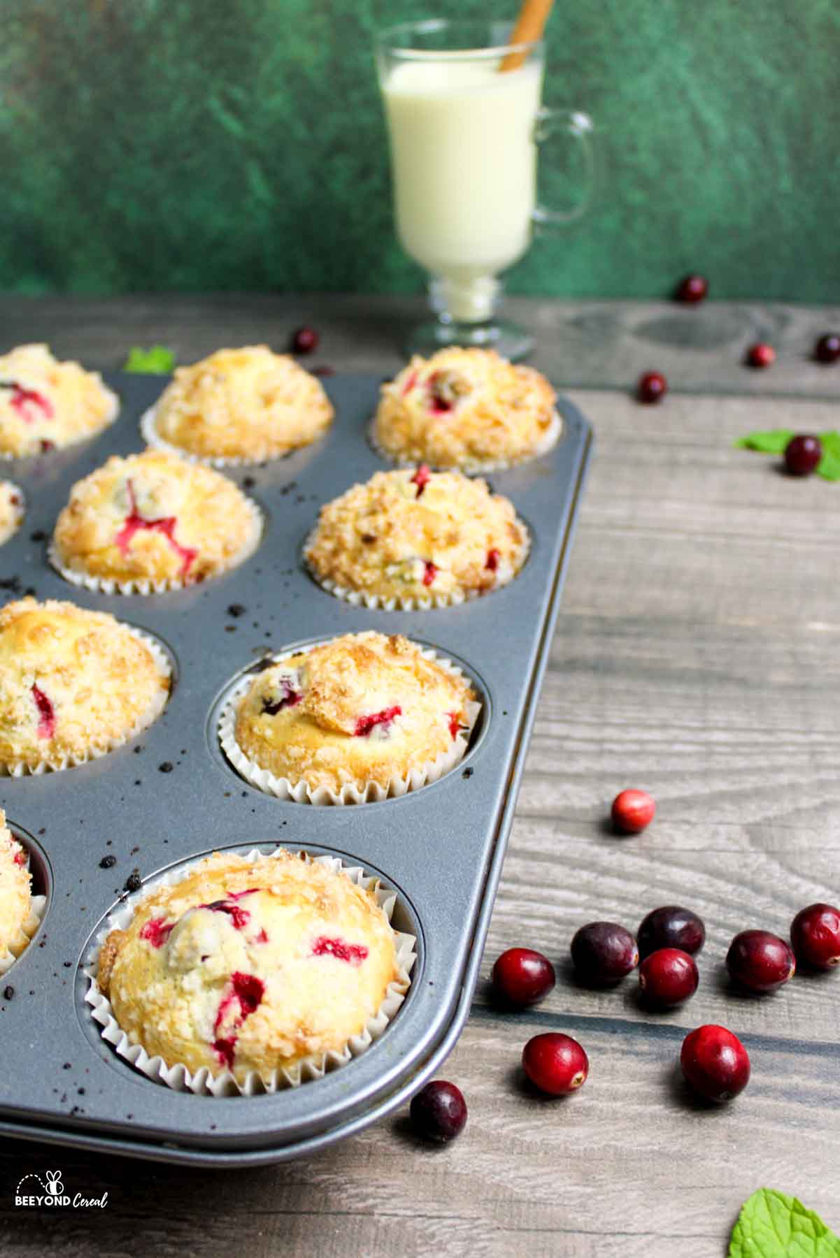 side angled view of a muffin tray full of cranberry eggnog muffins