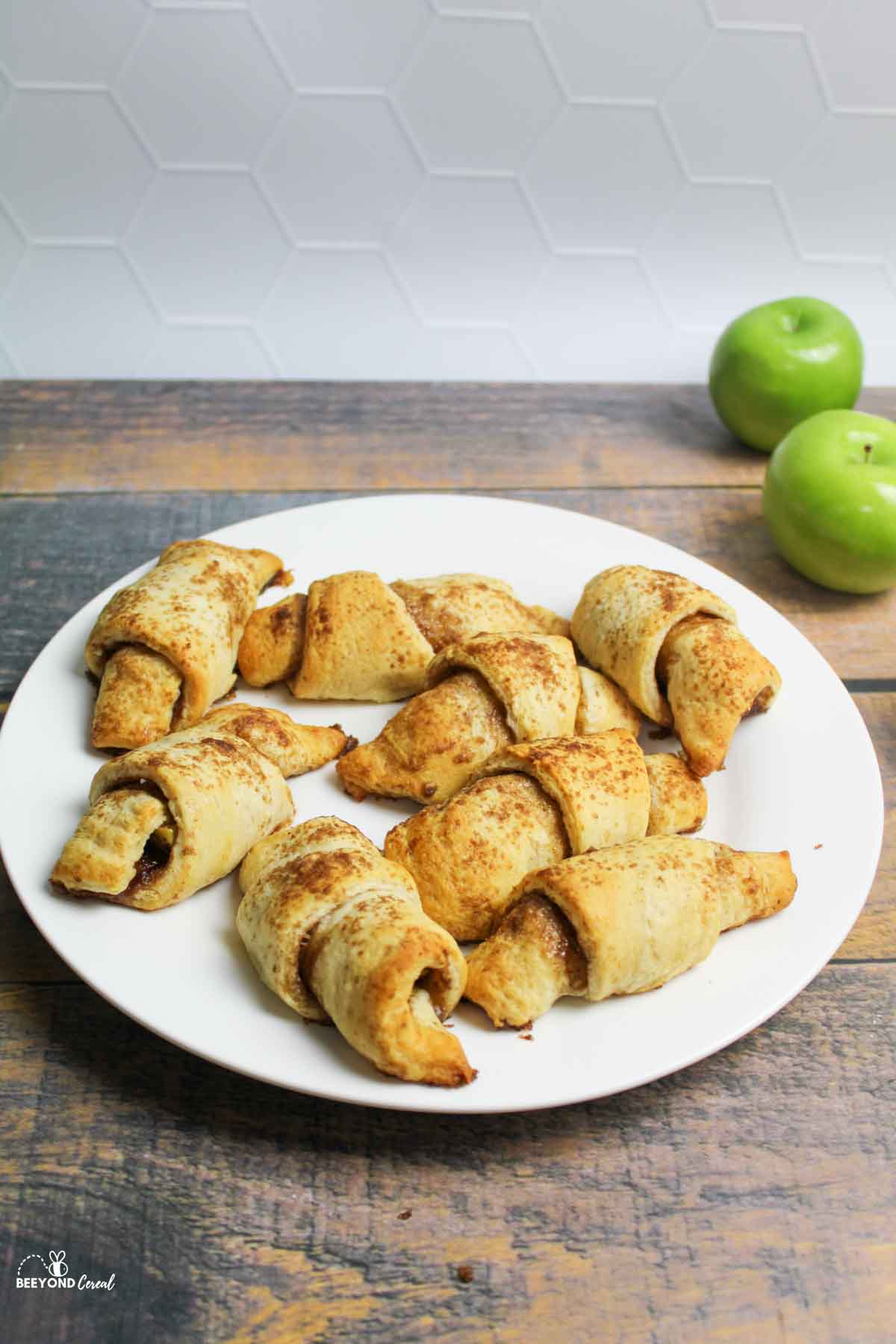 apple pie bites on a white plate with granny smith apples in the background
