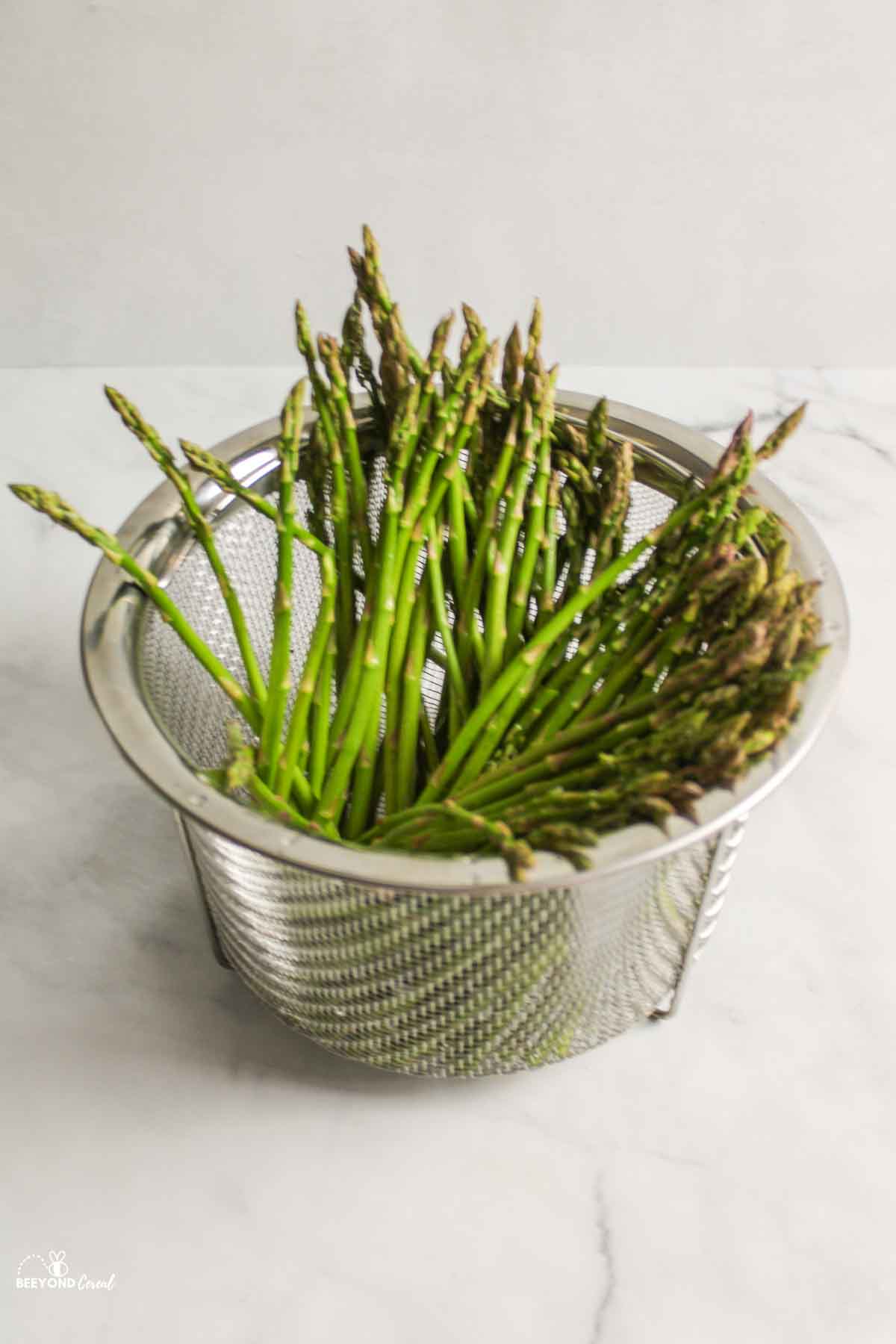 asparagus standing up in steamer basket