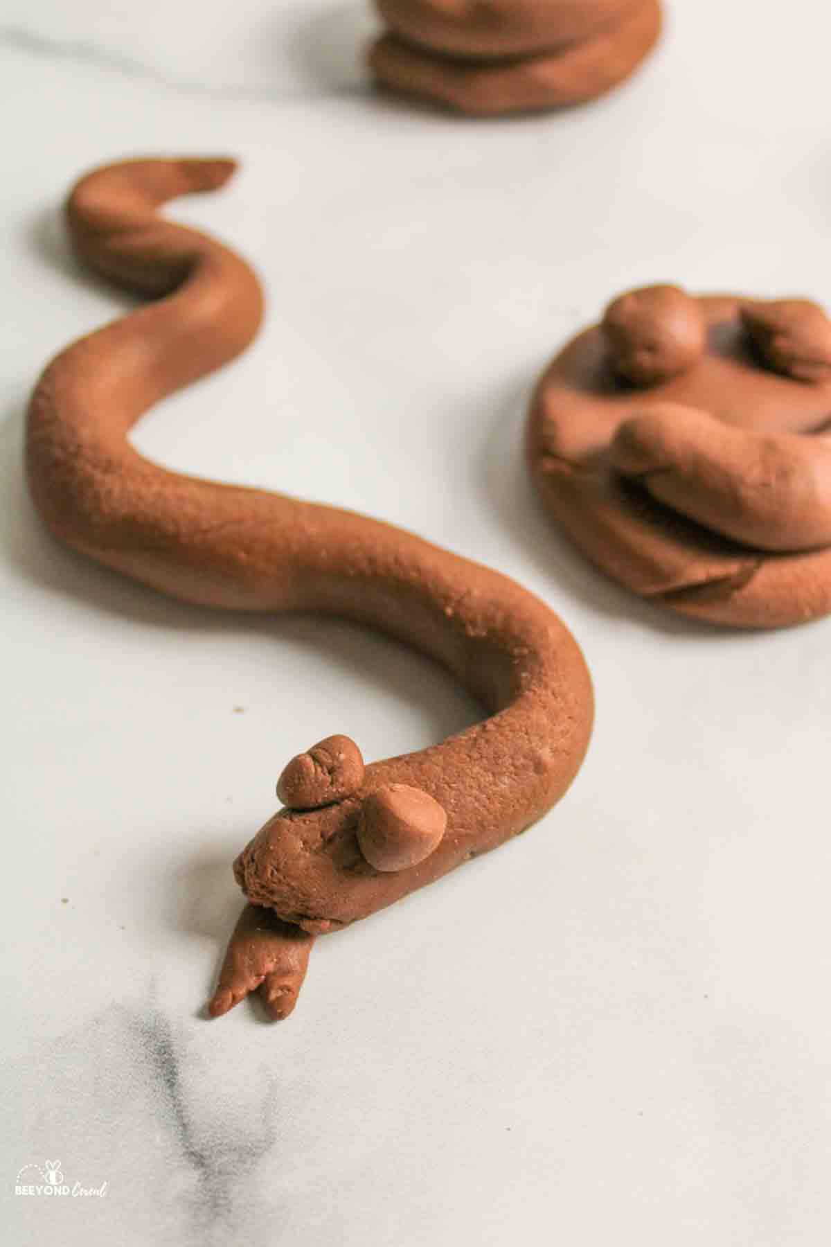 pudding playdough snake next to a smiley face