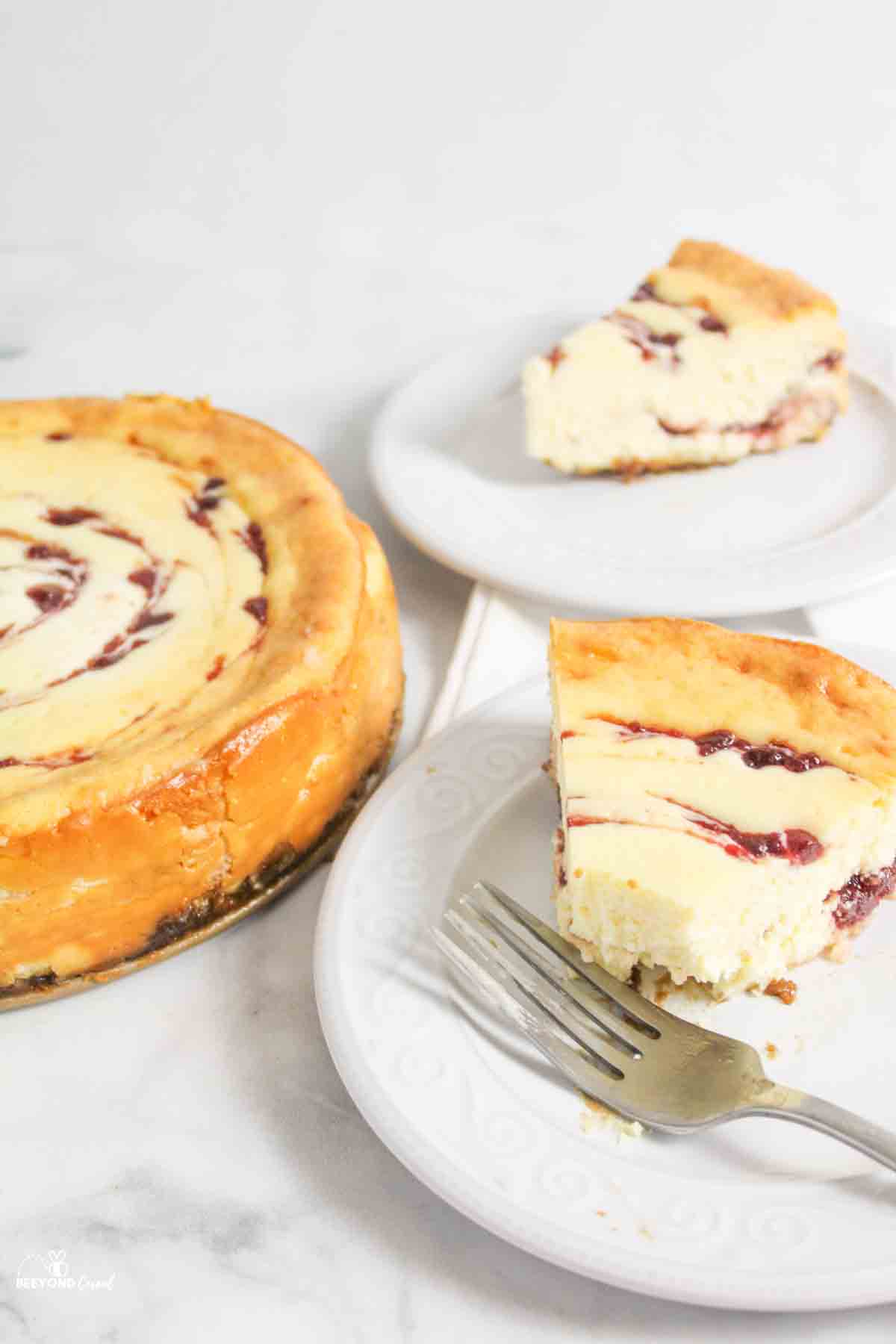 slices of cranberry white chocolate cheesecake on plates