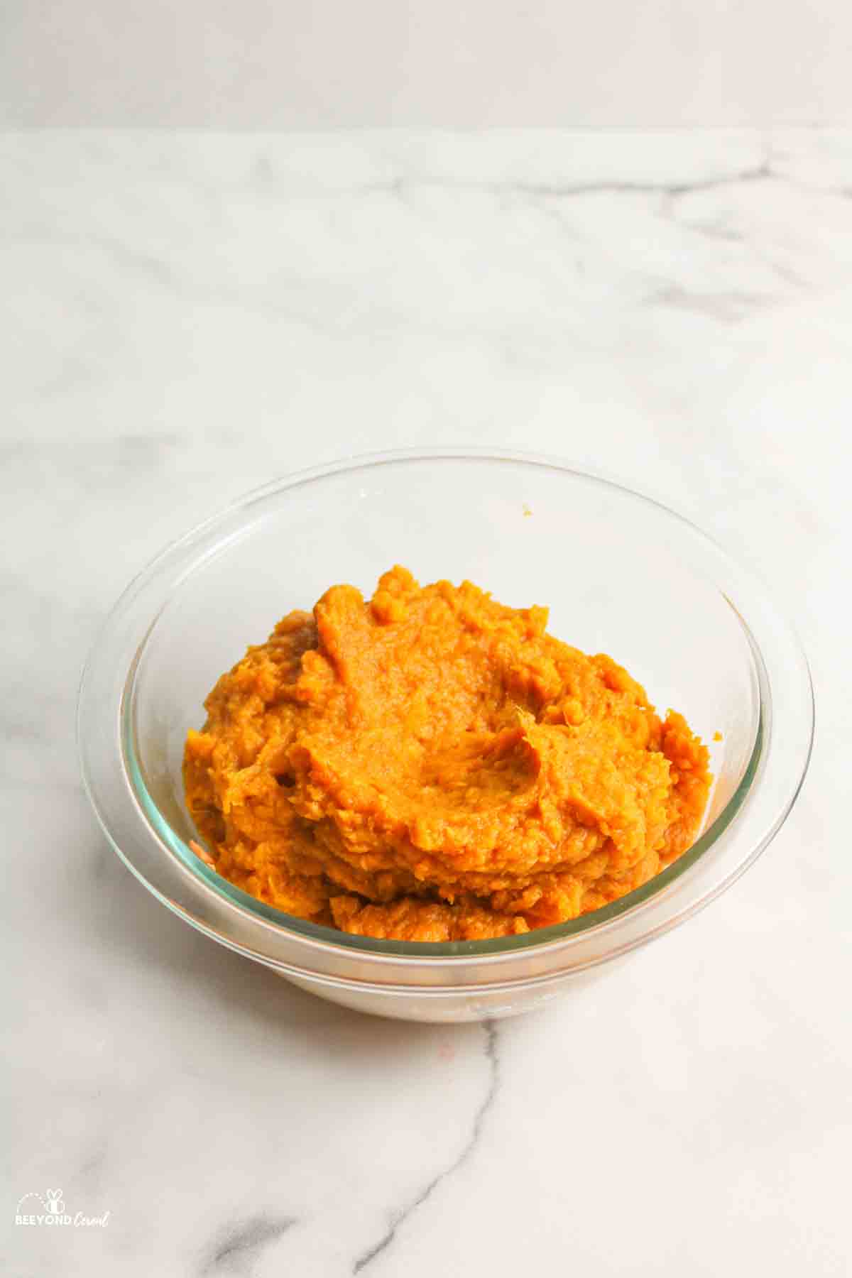 a glass bowl filled with mashed sweet potatoes