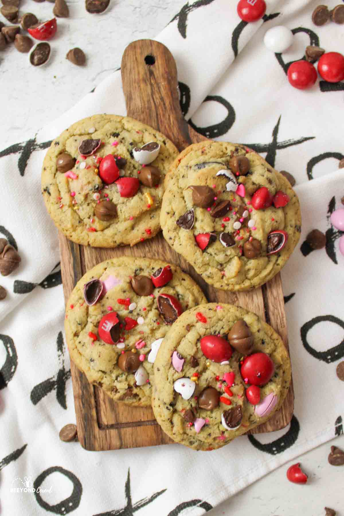 a wooden cutting board with 4 cookies on top.