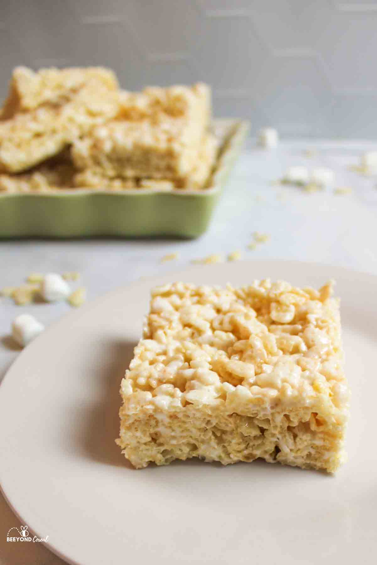 coconut oil rice krispies in a dish in background with a slice in front