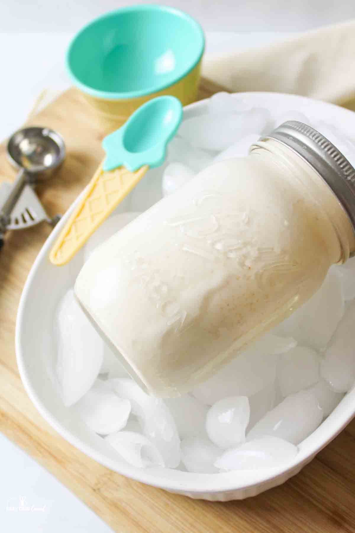 a mason jar filled with ice cream on a white bowl filled with ice.