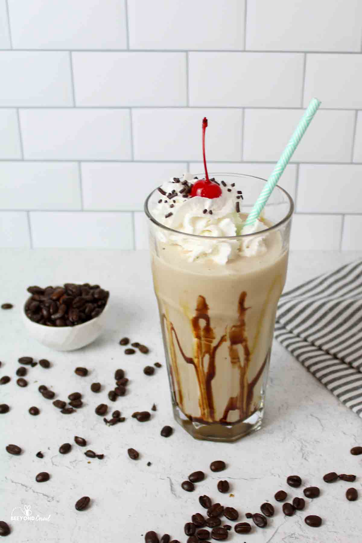 whipped cream and cherry topped coffee milkshake in a glass.