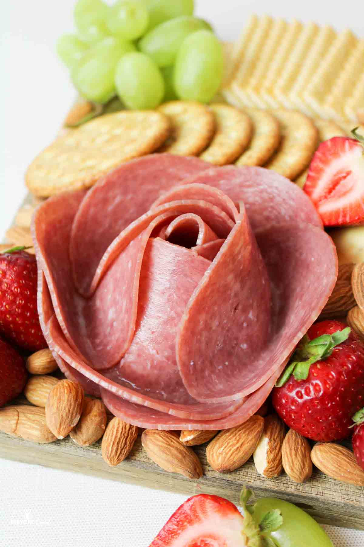 a close up view of a meat rose on a charcuterie board