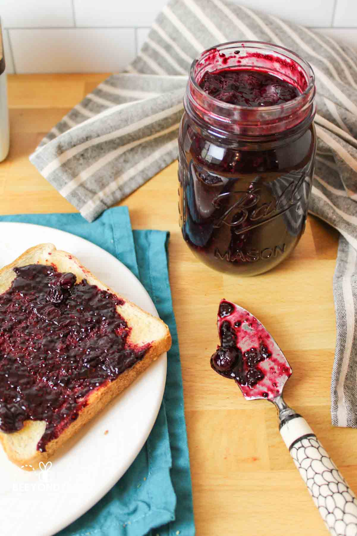 homemade blueberry jam being used on toast.