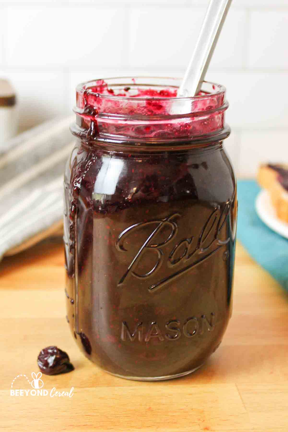 a jar filled with sugar free blueberry jam and a mess of jam running down the side of the jar