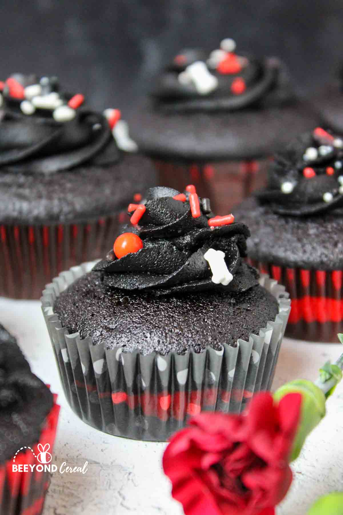 black cupcakes with red and white halloween themed sprinkles.
