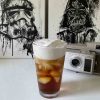 a picture of a cold foam iced coffee in front of darth vader posters