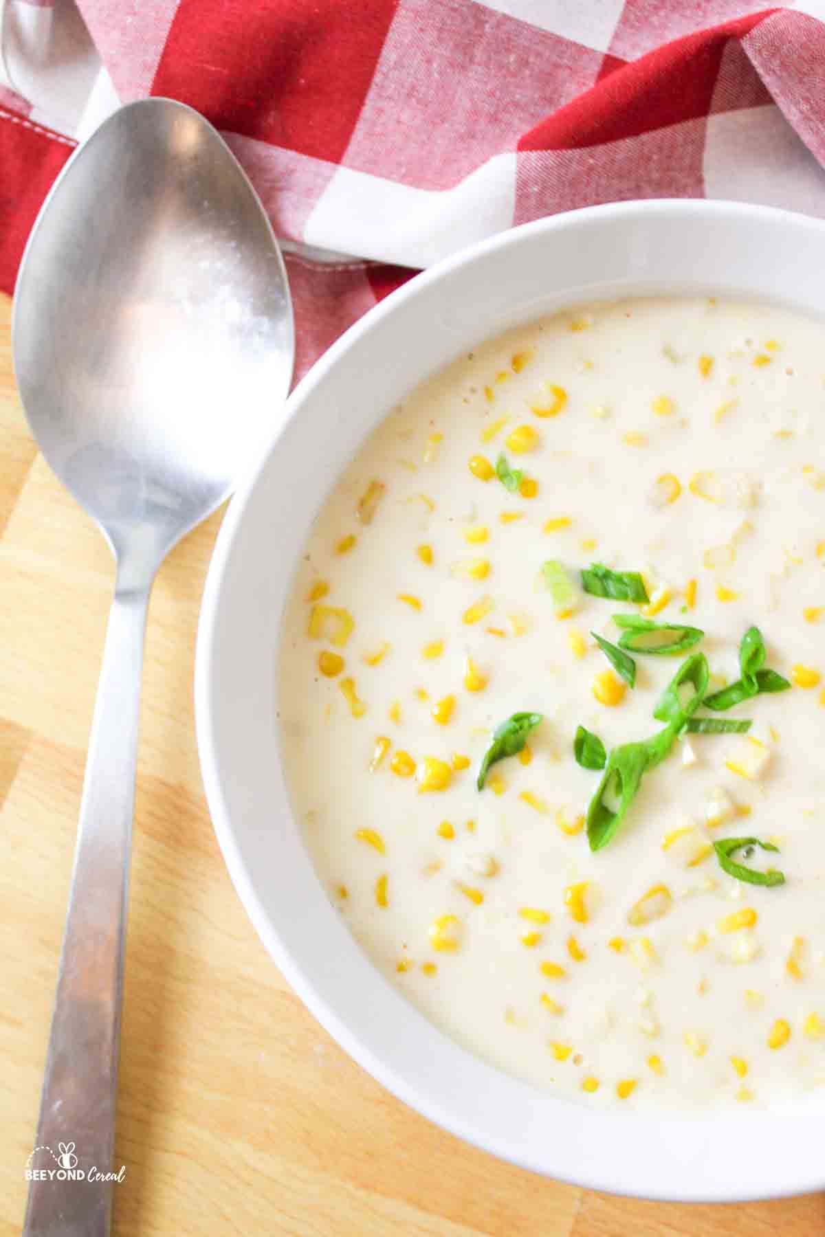 Casserole dish with creamed corn, large metal serving spoon.