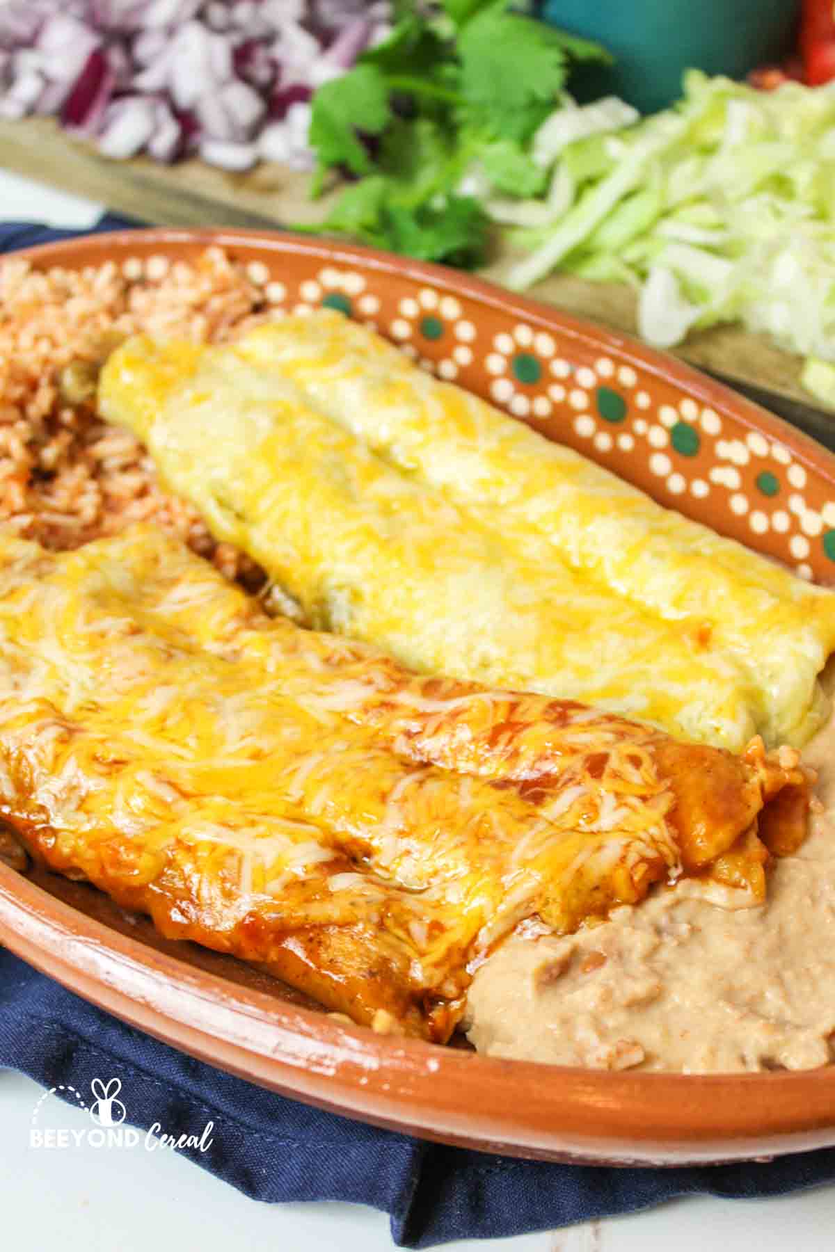 Plate with beef, chicken taquitos enchiladas, side dishes.