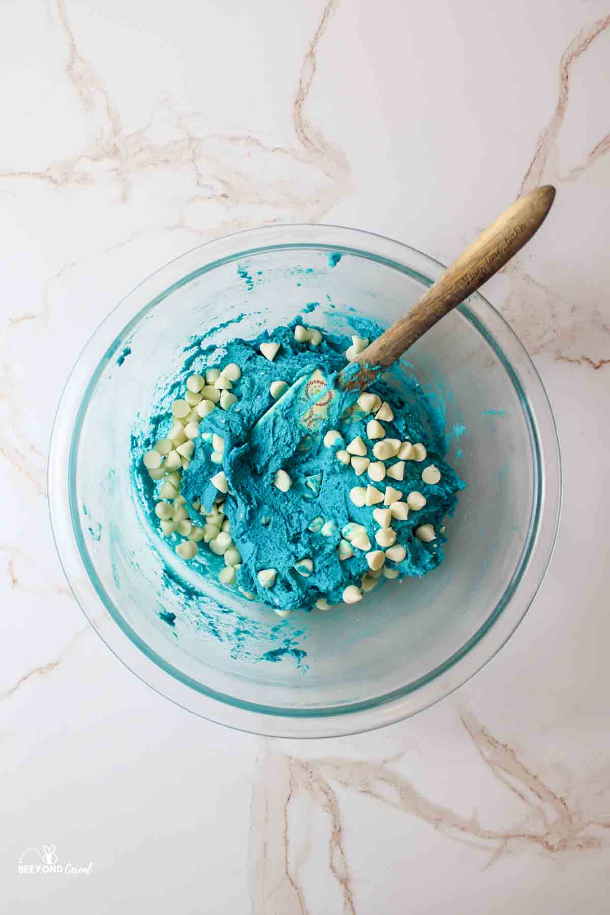 a bowl filled with blue cookie dough and white chocolate chips