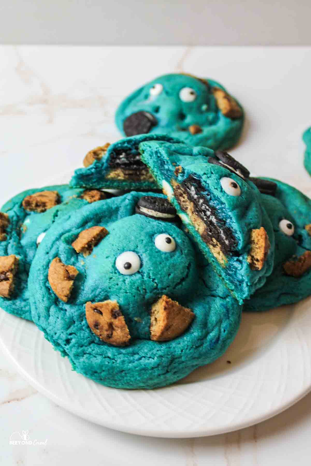 a plate full of blue cookies with eyes and other cookie pieces