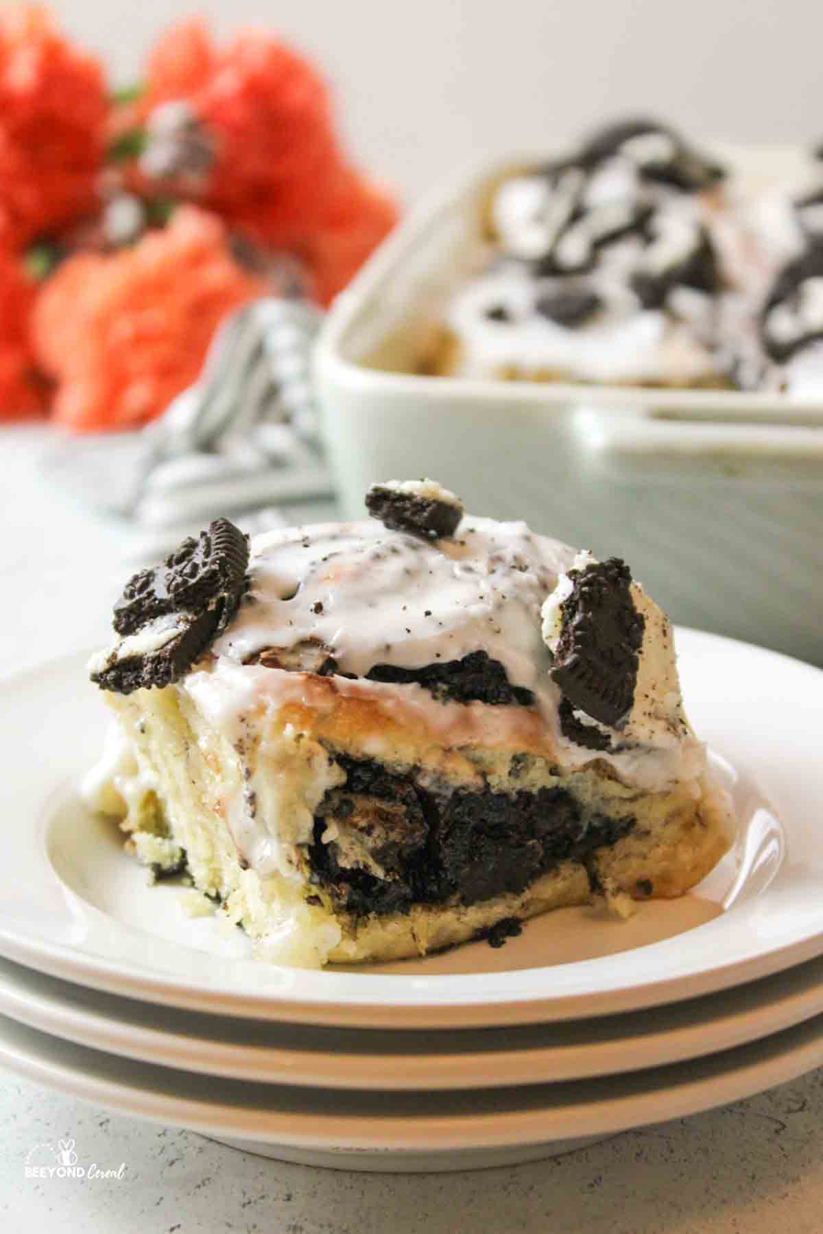 a stack of white plates topped with a cookies and cream oreo cinnamon roll