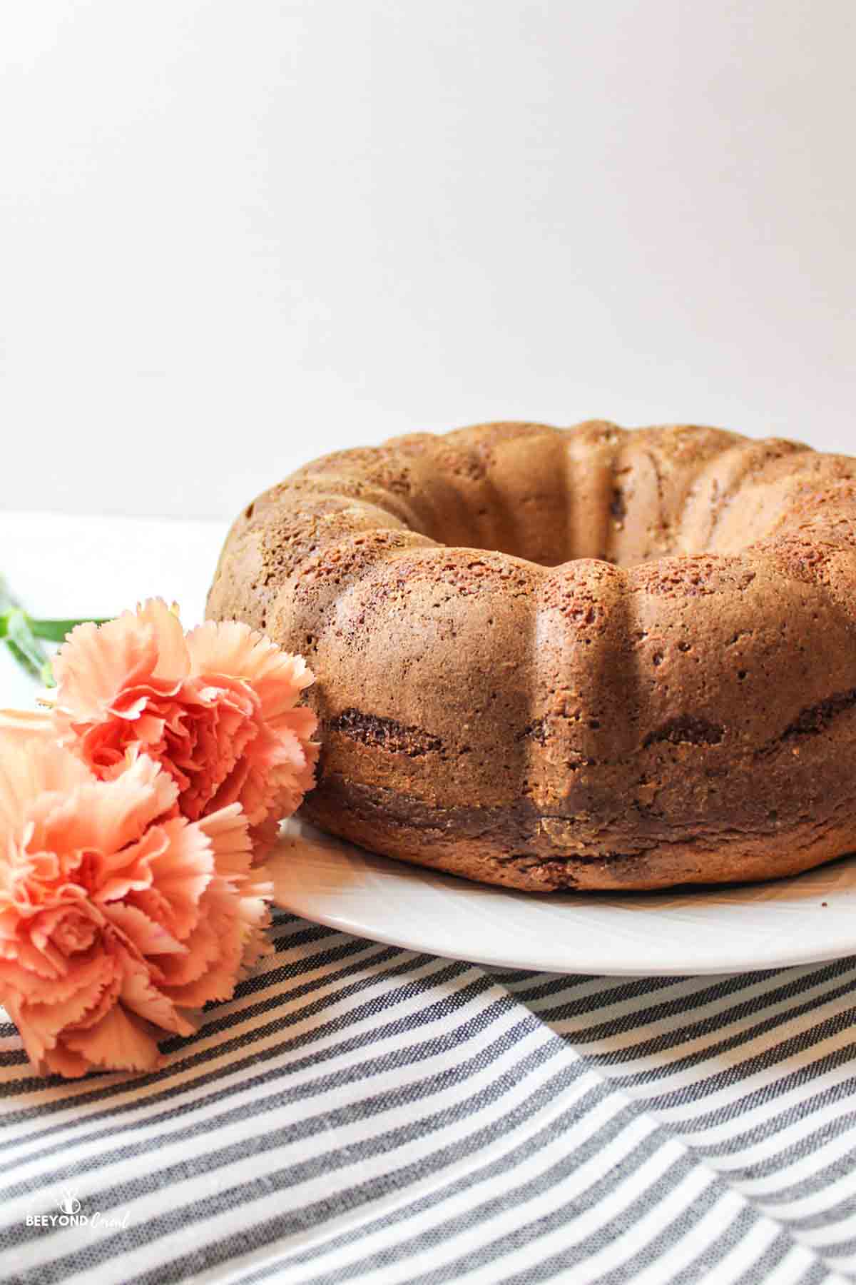 a fresh from the oven bundt coffee cake next to fresh pink flowers