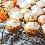 a close up of frosted pumpkin cupcakes ona wire rack