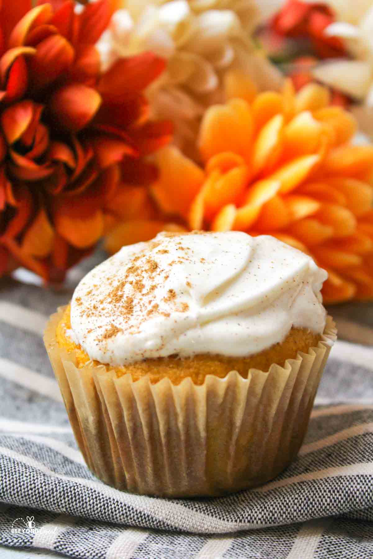 a spiced pumpkin cupcake with cream cheese frosting