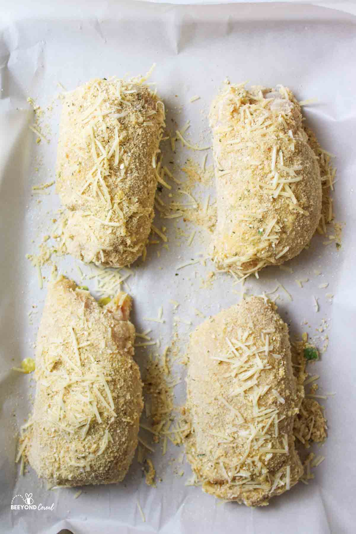 four rolled chicken breasts with cheese and breading on the outside.