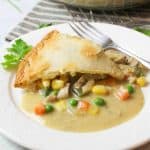 an upclose view of a chicken pot pie on a plate with a fork