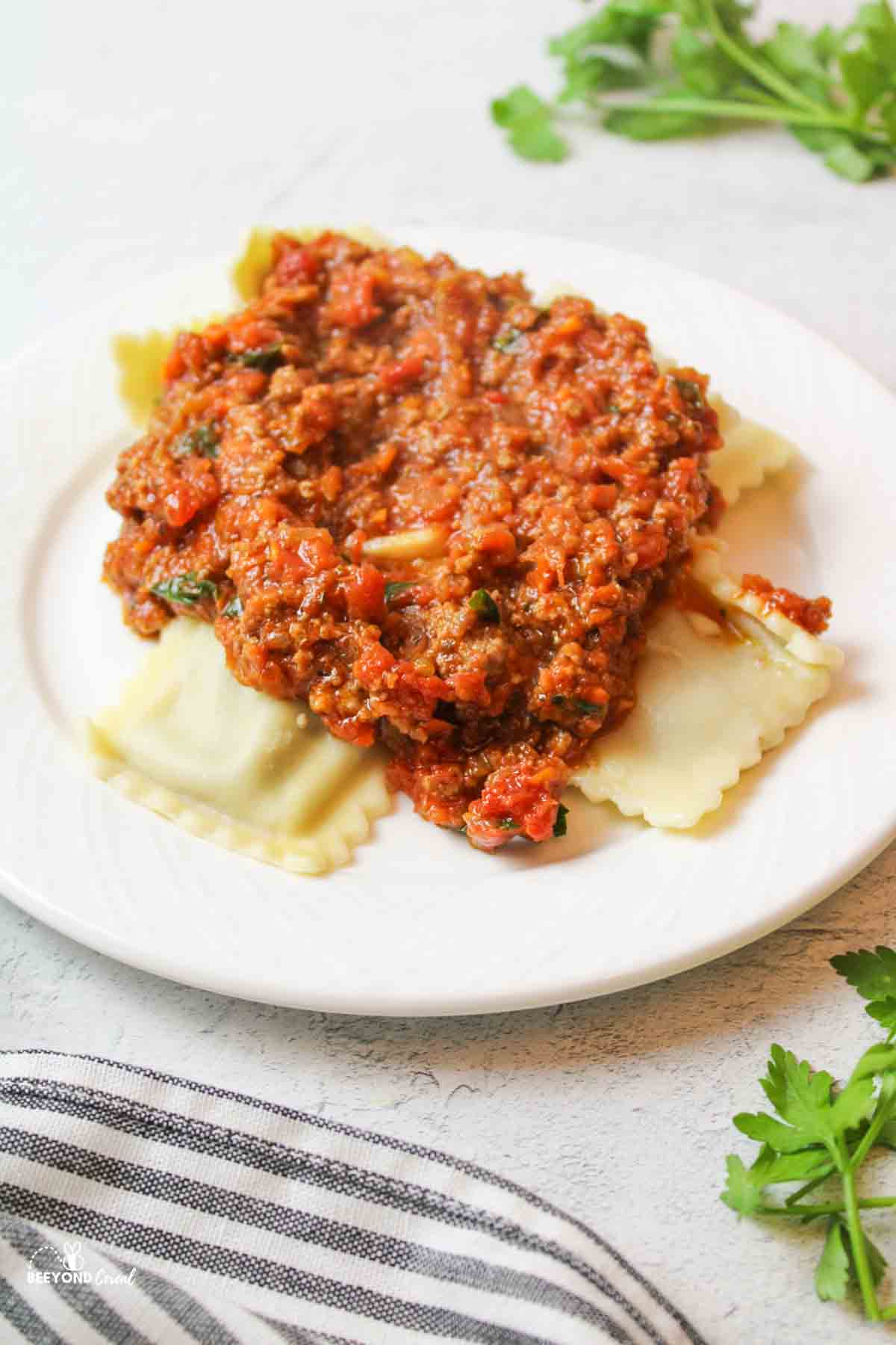 a white plate topped with ravilois and homemade ragu spaghetti sauce
