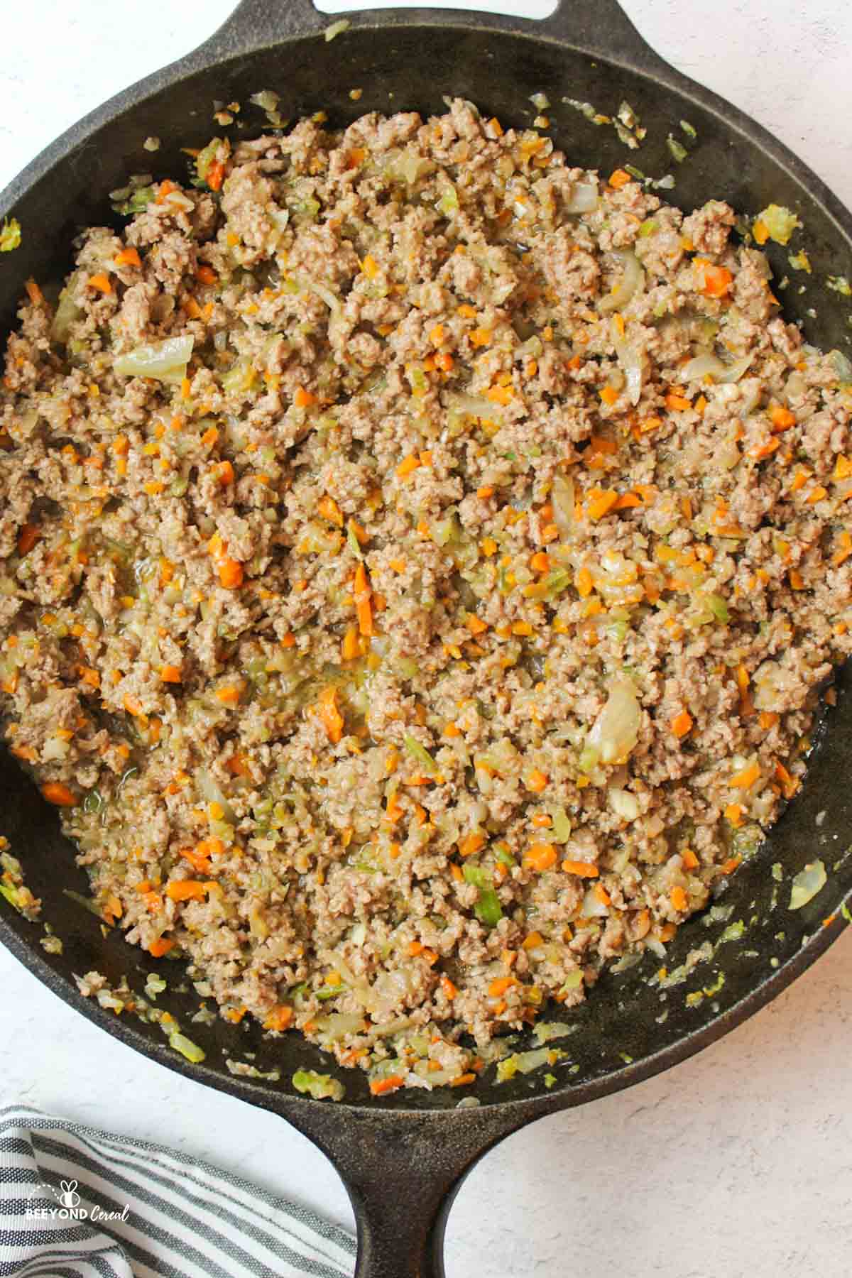 cooked ground beef with finely chopped veggies in a cast iron skillet