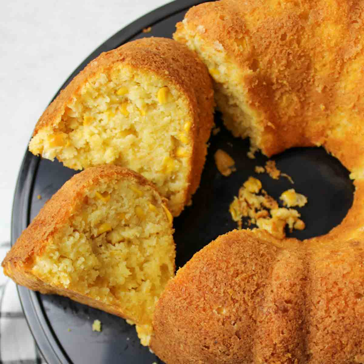 cornbread bundt cake with some pieces sliced.