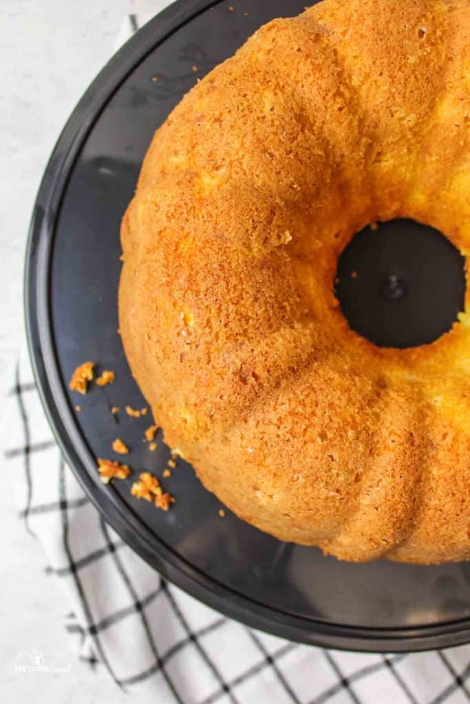 aerial view of a cornbread bundt cake on a black serving tray with some crumbs to the side
