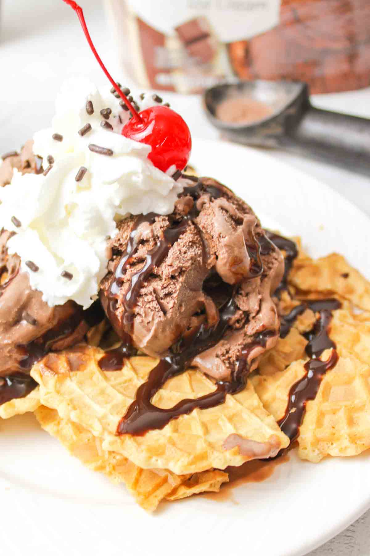 a close up of chocolate ice cream nachos with chocolate syrup and a cherry