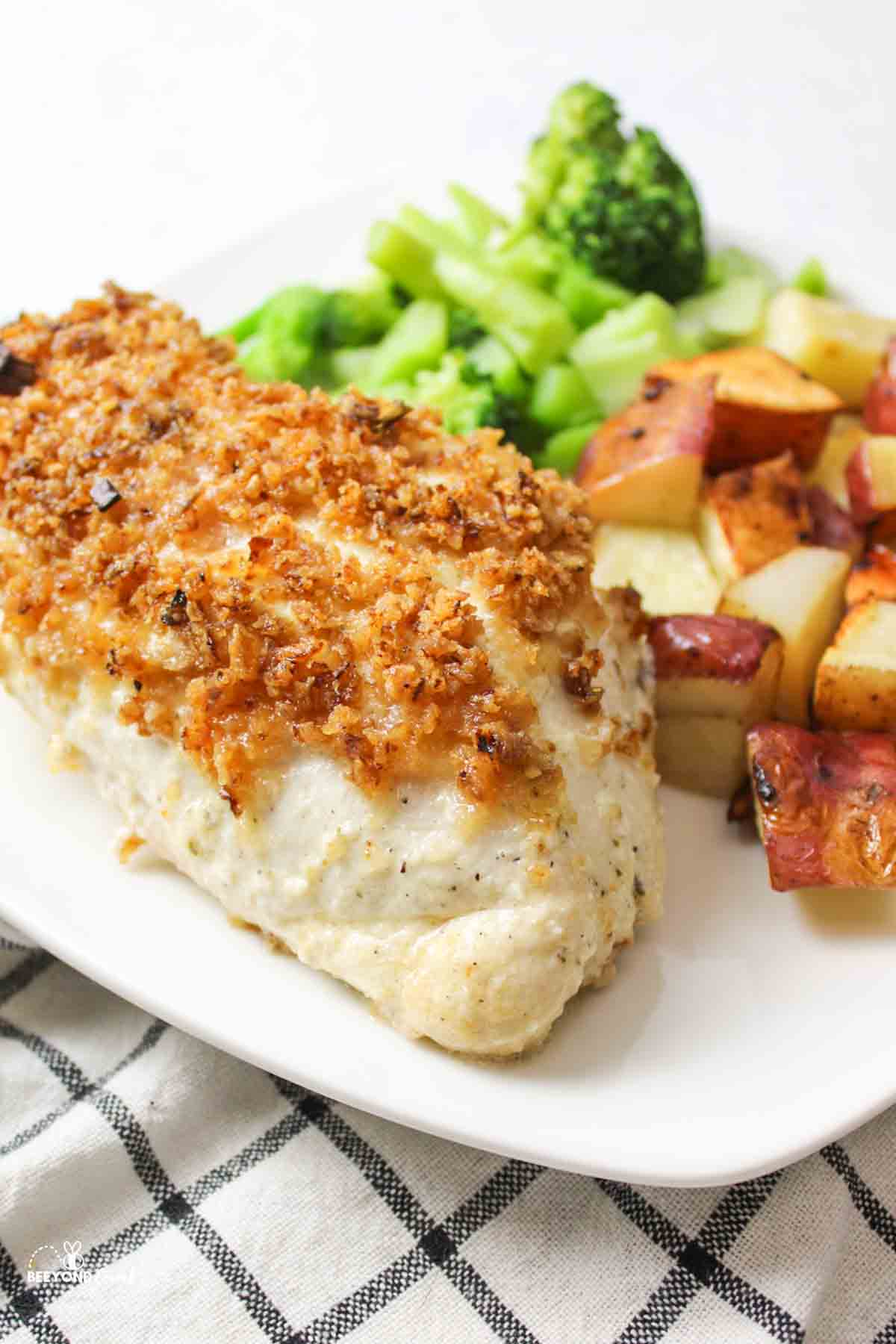 a crispy onion chicken on a plate with side dishes.