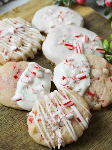 an upclose view of white chocoalte covered peppermint shortbread cookies on a wooden surface