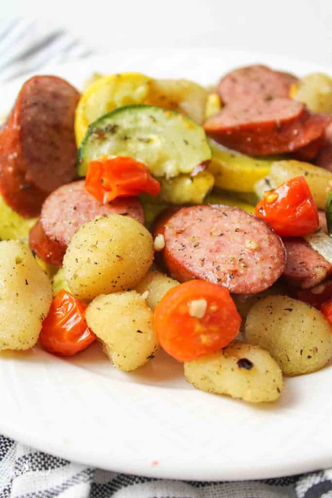 close up of a plate with gnocchi with sausage and vegetables