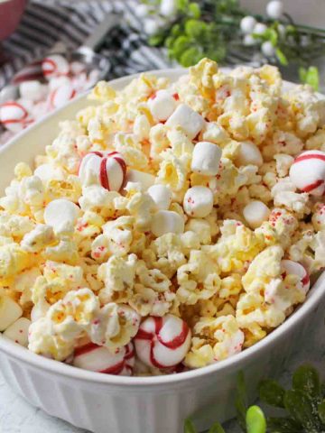 a white oval dish filled with peppermint popcorn.