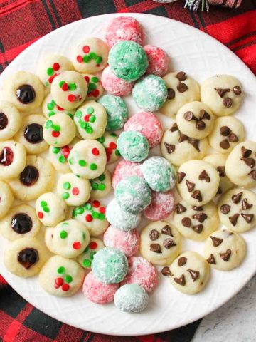 upclose aerial view of a white plate topped with christmas cookies made elf sized and tiny