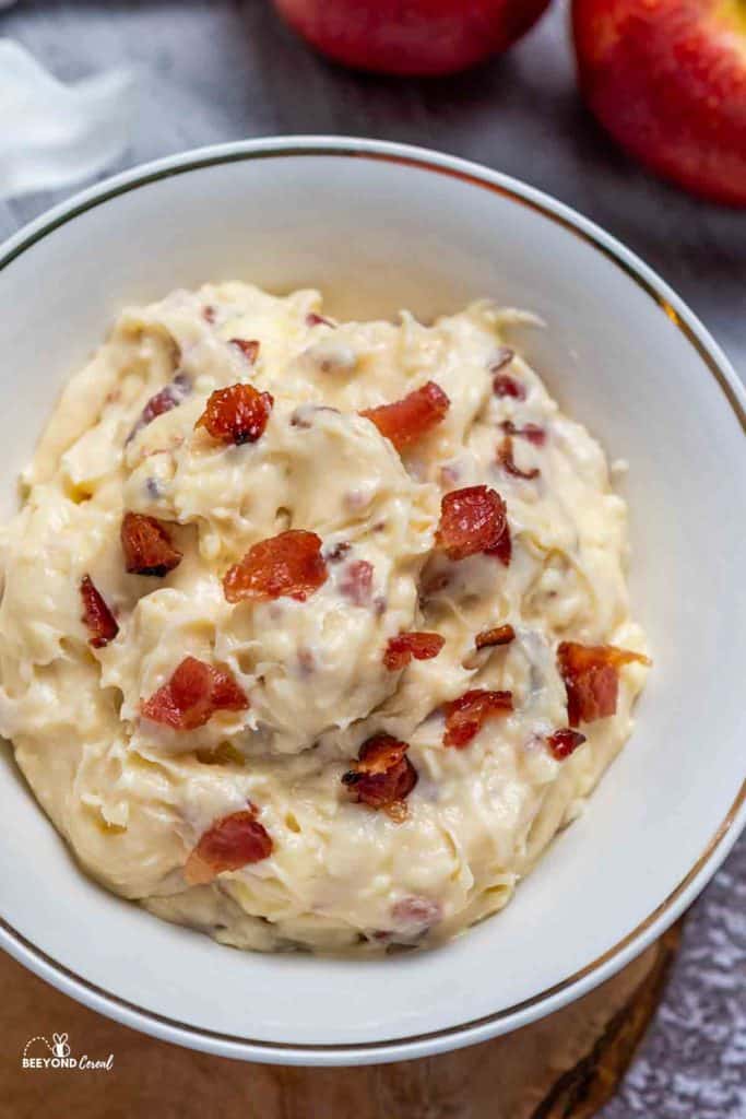 maple bacon dip in a bowl topped with crumbled bacon
